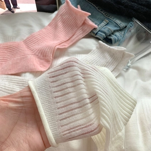 Détail des chaussettes côtelées rose et beige montrant le tissu mince respirant