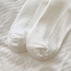 Detailed macro view of white vertical ribbed knit texture on high quality cotton socks