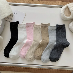 Set of 7 colorful speckled knit crew socks in neutral tones for women on a tray