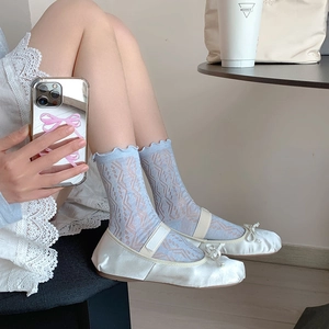Dettaglio di calze a rete azzurre con volant e scarpe Mary Jane bianche in stile vintage
