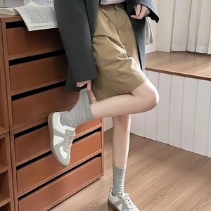 Close-up of gray cotton crew socks with white trainers and khaki shorts for JK fashion