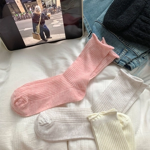 Détail de chaussettes en coton côtelé avec élégant bord festonné en rose et beige