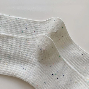 Close-up of white ribbed crew socks with colorful flecks and soft knitted texture