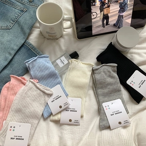 Détail de chaussettes en maille à bords volantés et texture côtelée en couleurs assorties