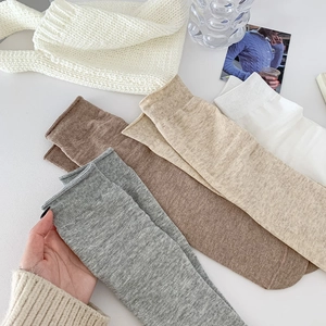 Detailed view of ribbed cuffs on soft cotton crew socks in grey, beige, and white colors