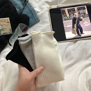 Détail de la maille côtelée verticale et des bords ondulés sur trois paires de chaussettes
