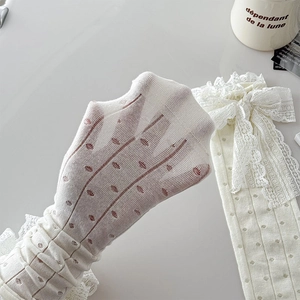 Vue détaillée de chaussettes en dentelle blanche avec nœuds élégants et maille ajourée