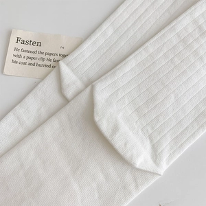 Close-up of white ribbed crew socks showing soft knit texture and vertical stripe pattern