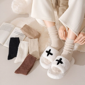 Close-up of ribbed knit thermal socks in neutral colors with cozy plush cross pattern slippers