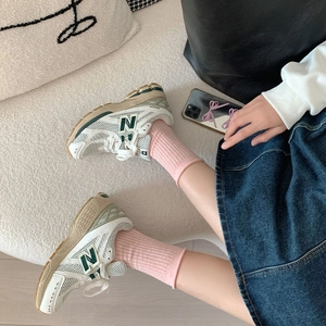 Vue détaillée des baskets rétro en mesh blanc et vert avec design classique à lacets