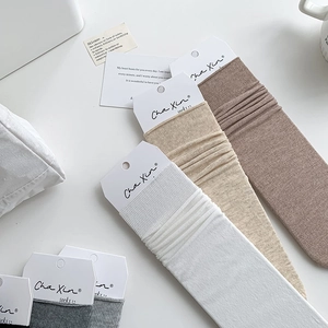 Close-up of premium ribbed knit crew socks in neutral tones with minimalist packaging