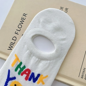 Detail of white invisible sock featuring colorful THANK YOU embroidery and smiley face