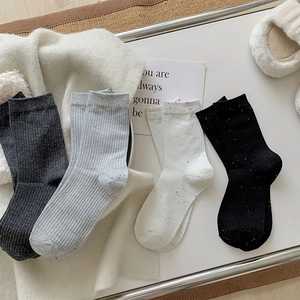 Detailed close-up of four pairs of ribbed nep yarn crew socks in neutral color tones