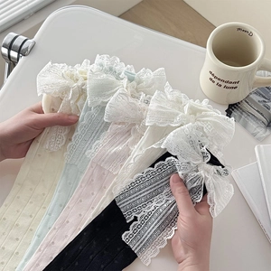 Détails de chaussettes en maille avec de grands nœuds en dentelle dans divers tons pastel