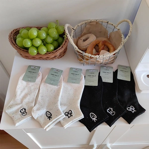 Close-up of cotton socks with cartoon embroidery and colorful flecks in a lifestyle setting