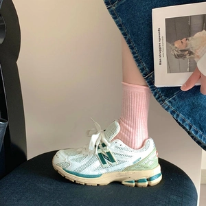 Gros plan de chaussettes roses portées avec des baskets rétro en mesh et une jupe en jean