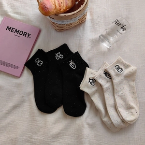 Detail of embroidered cartoon patterns on nep yarn socks with bear and strawberry motifs