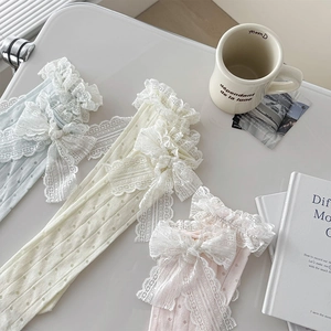 Détail de chaussettes à nœud en dentelle en bleu clair, crème et rose tendre