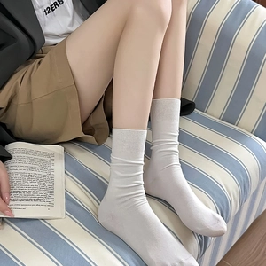 Classic white crew socks with ribbed texture for women shown in a cozy home setting
