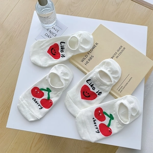 Detail of four pairs of white cotton low cut socks with cherry and heart embroidery