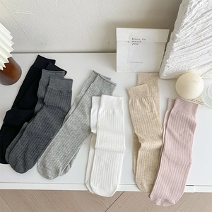 Detailed view of vertically ribbed cotton mid-calf socks in six neutral pastel colors