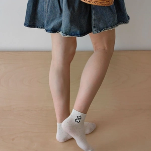 Close-up of white cotton socks featuring a cute black dog embroidery and colorful dots