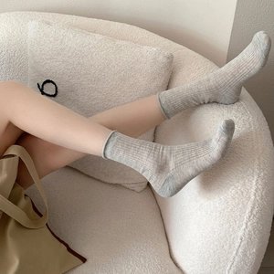 Chaussettes japonaises gris clair à bord roulé avec texture côtelée portées au pied
