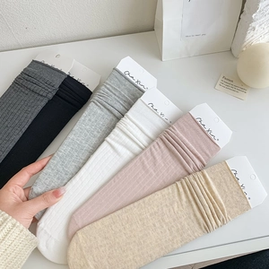 Detailed knit texture of six pairs of ribbed slouch socks in assorted neutral colors
