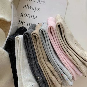 Close-up of assorted confetti knit mid-calf socks in diverse pastel and neutral colors