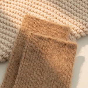 Close-up of thick ribbed knit texture on warm camel wool blend socks for winter comfort