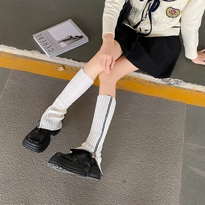 White knitted leg warmers with side zipper design paired with black platform shoes
