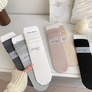 Detailed view of ribbed crew socks in multiple solid colors with clean branded packaging
