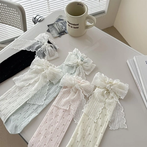 Détails de quatre paires de chaussettes à nœuds en dentelle noir, vert, rose et beige