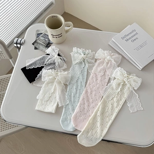 Vue à plat de chaussettes en résille avec nœuds en dentelle en cinq couleurs douces