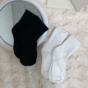 Classic black and white ribbed crew socks for women on a cozy minimalist background