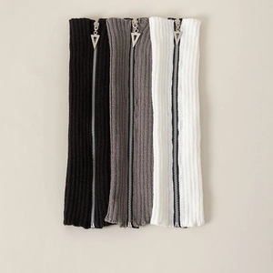 Detail of ribbed knit leg warmers with silver metal zippers in black grey and white