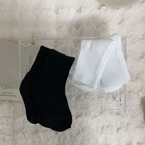 Thick winter mid-calf sports socks in black and white rib cotton on plush background