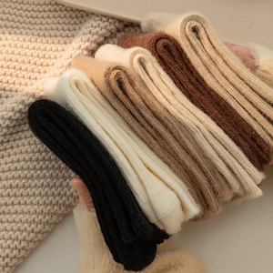 Close-up of five pairs of thick knitted thermal socks in warm earth tones for winter