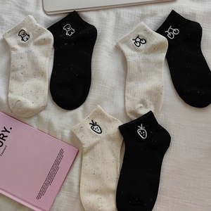 Detail of cotton socks featuring embroidered bear, bicycle, and strawberry motifs