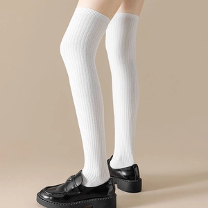 Detailed view of white over-the-knee socks with vertical ribbing and cotton texture