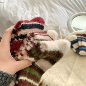 Gros plan de chaussettes en peluche rayées montrant la texture douce et chaude