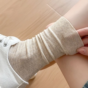 Detailed texture of beige vertical striped mid-calf socks with white sneakers