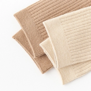 Detail of ribbed knit over-the-knee socks in beige and brown with soft texture