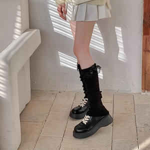 Details von schwarzen Strick-Stulpen mit Spitzenbesatz und Schleife im japanischen Stil