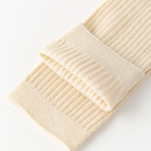 Macro shot of beige ribbed knit over-the-knee socks with thick anti-slip folded cuff