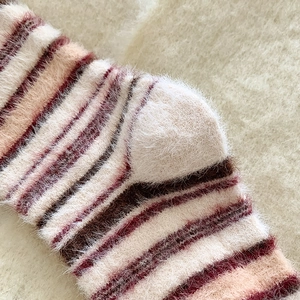 Détail de chaussettes rayées en faux vison doux avec texture pelucheuse épaisse et chaude