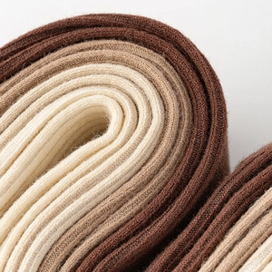 Macro detail of ribbed knit fabric texture in earthy brown and beige color tones