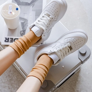 Weiße Low-Top Sneaker kombiniert mit stylischen senfgelben Strick-Wadenstrümpfen