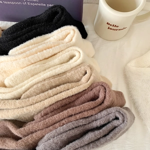 Nahaufnahme dicker Strick-Wintersocken in neutralen Tönen auf weißer Tischdecke