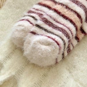 Détail de chaussettes rayées en velours de vison synthétique doux et chaud